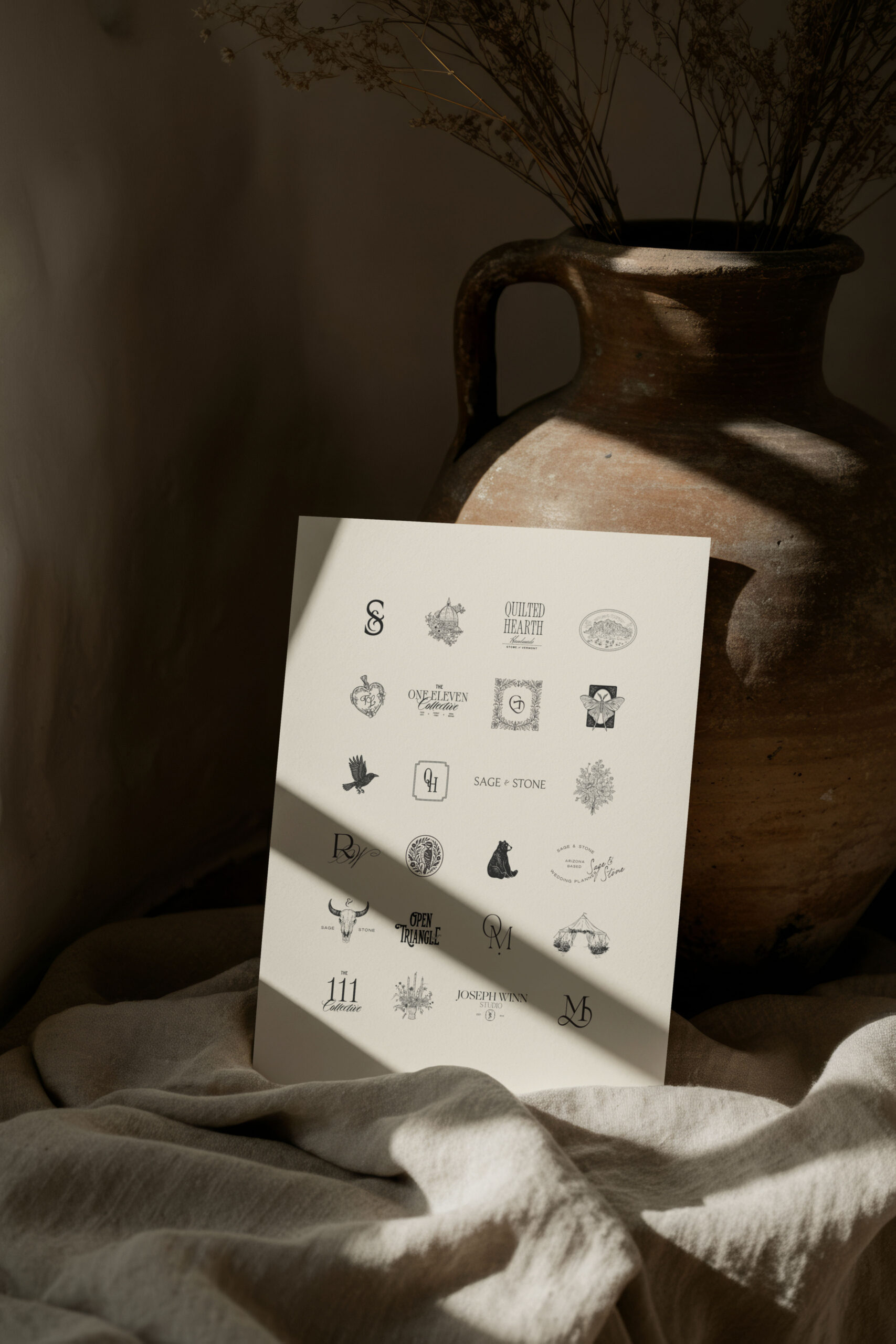 Printed brand identity elements styled with neutral decor, illustrating how strategic branding supports premium positioning for interior designers.