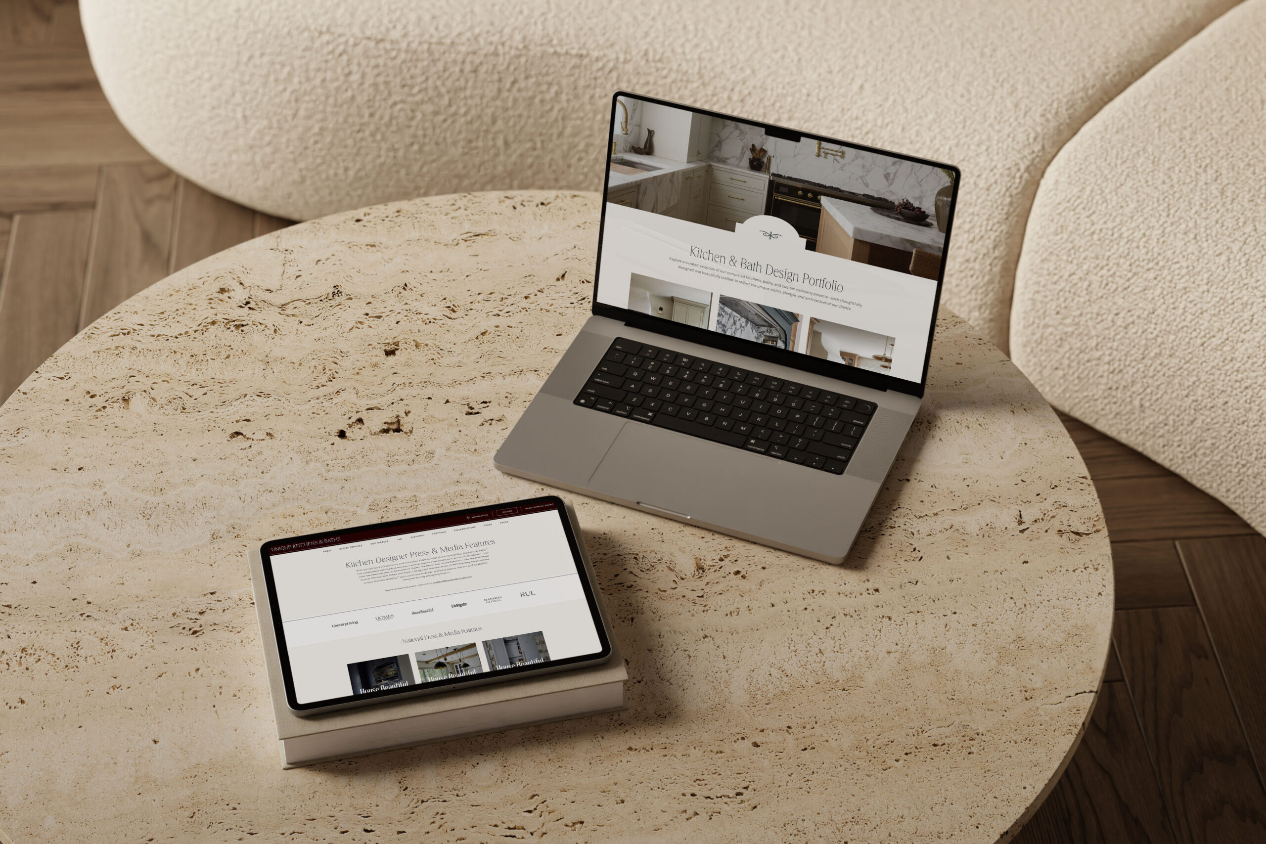 Laptop and tablet displaying a luxury interior designer website on a stone coffee table, showcasing a seamless desktop and mobile user experience.